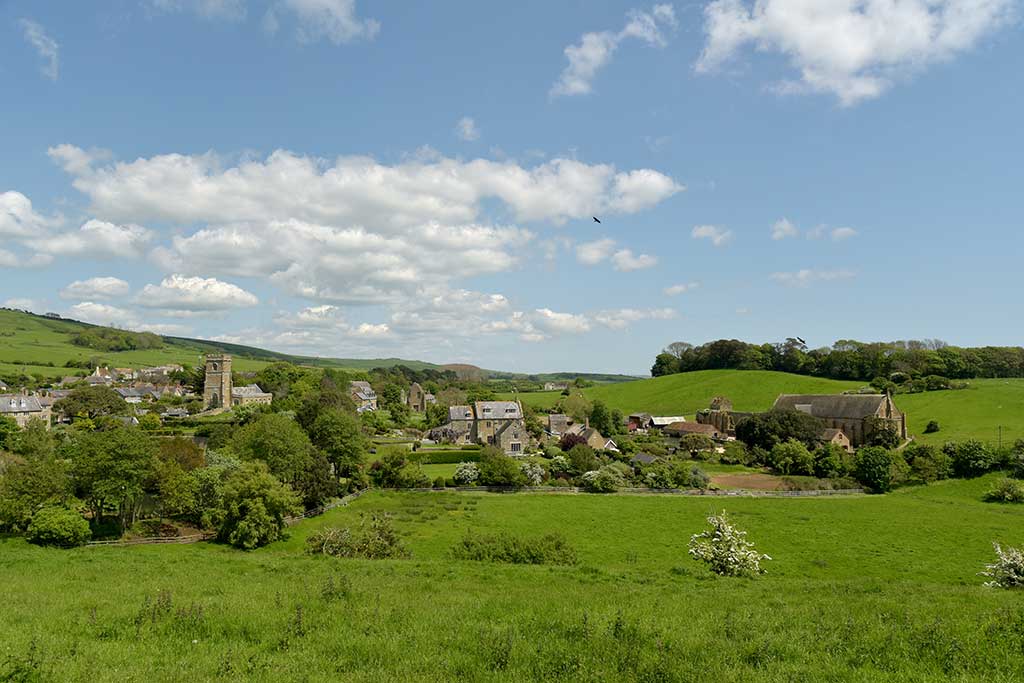 Abbotsbury village. St Nicholas' Church on the left with the abbey ruins in the centre. The Children's Farm is on the right.
