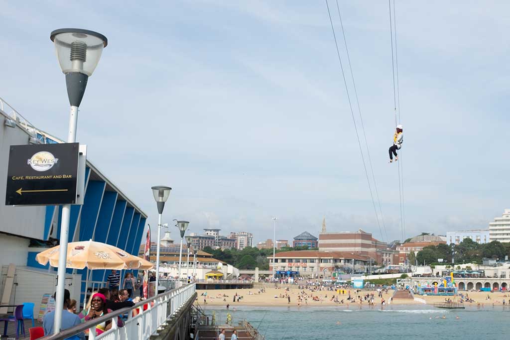 Person travelling along the ZipLine from Bournemouth Pier over the sea to the beach.