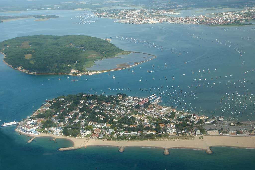 Aerial view of Poole Harbour showing sandbanks peninsula at the bottom of the image and Brownsea Island in the middle. Photo taken from a light aircraft.