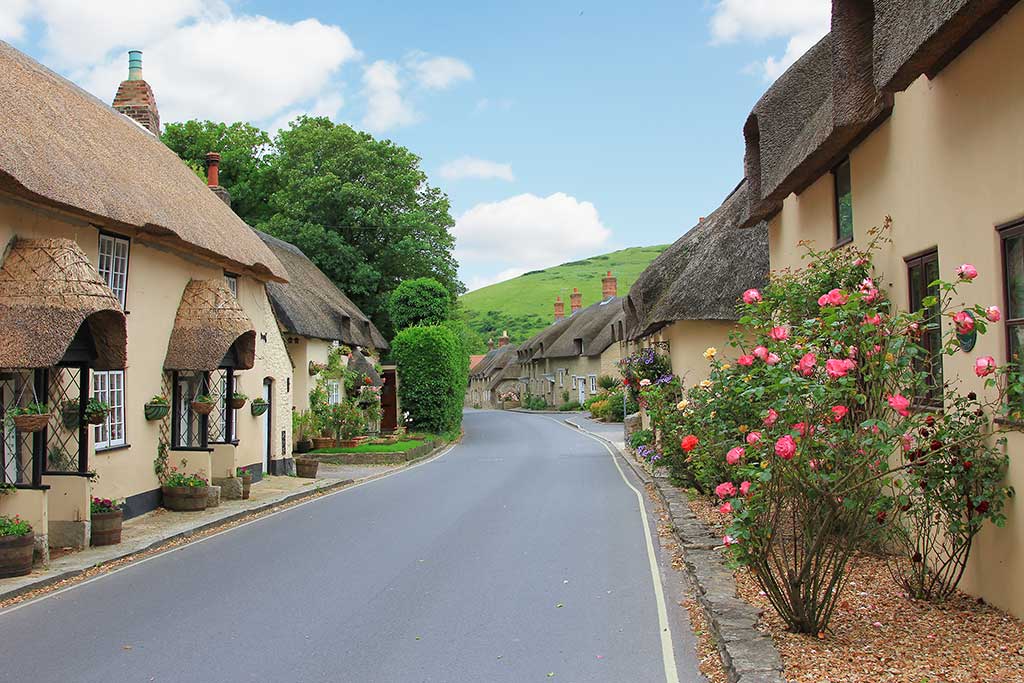 West Lulworth Village. Photo shows the High Street lined with pretty thatched cottages.
